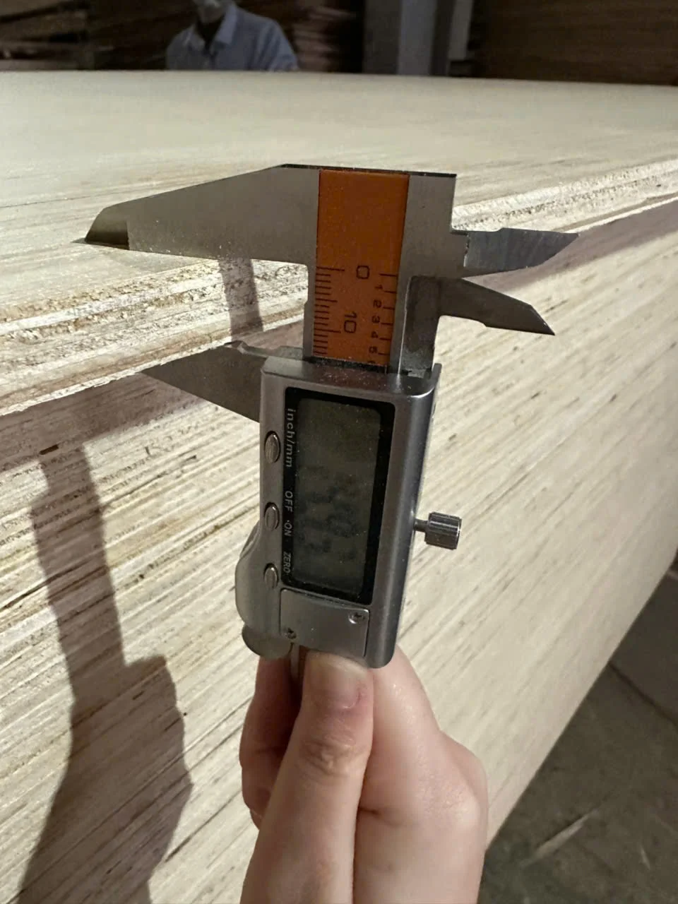 Quality inspection of 15mm plywood thickness at Vietnam HCPLY factory showing measurement process